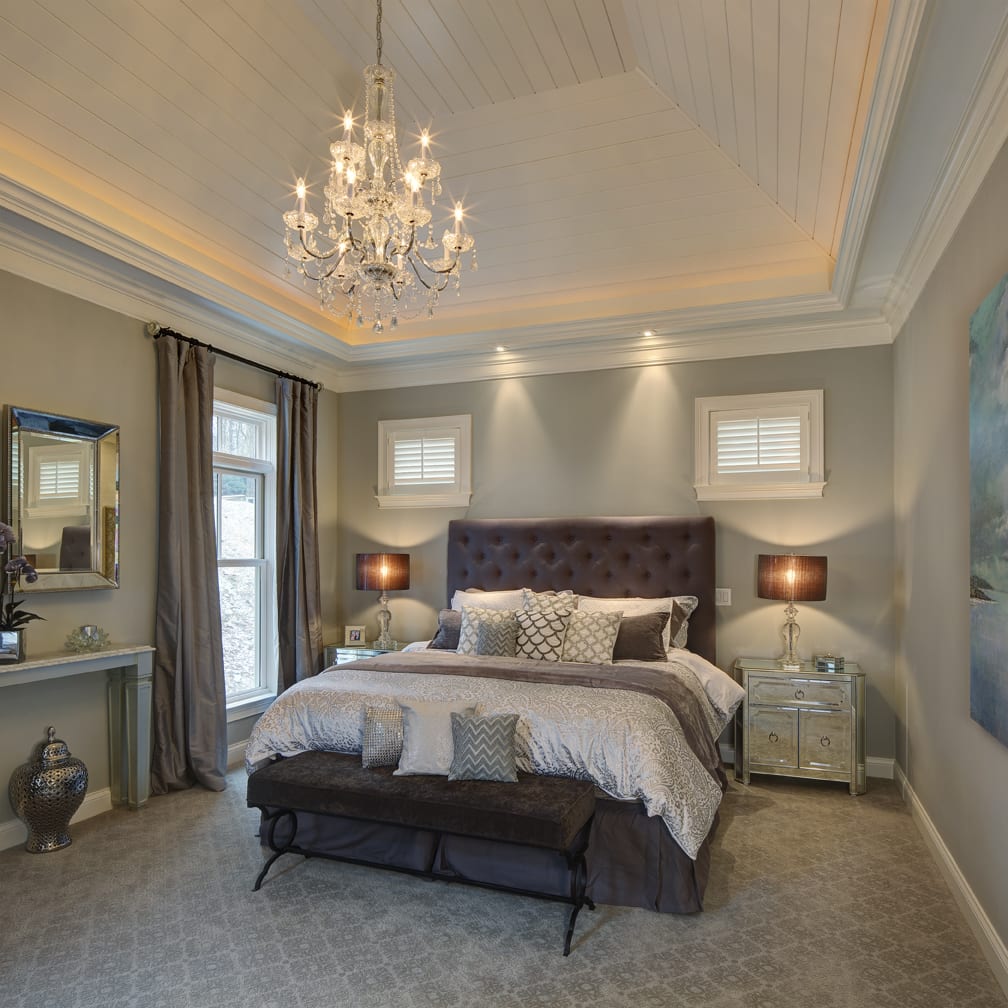 gray bedroom with a chandelier