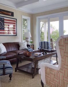 library with a brown couch, two blue and white striped chairs, and a tan chair