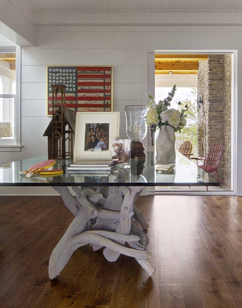 glass table with a picture frames, flowers, notebooks, and ping pong paddles on it