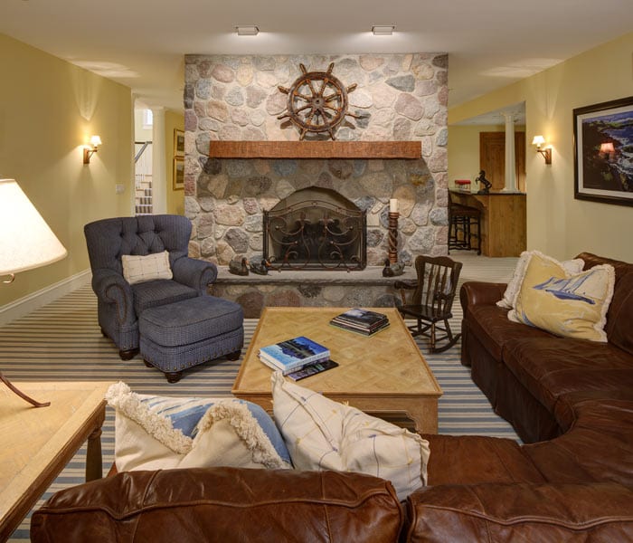 picture of a family room with a stone fireplace and seating