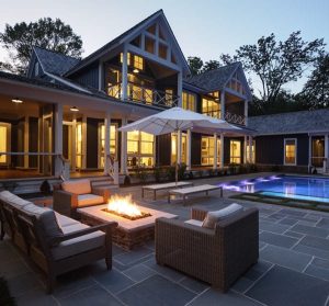 picture of a home with a swimming pool and fire pit at dusk