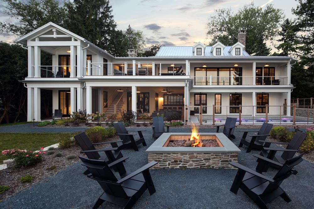 picture of a white home with a pool and fire pit