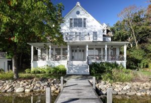 picture of a white home with a dock on a lake