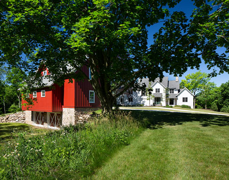 picture of a red barn and tree with a white home in the background