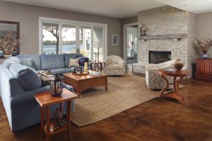 picture of a living area with a stone fireplace, blue couch, and patterned armchairs