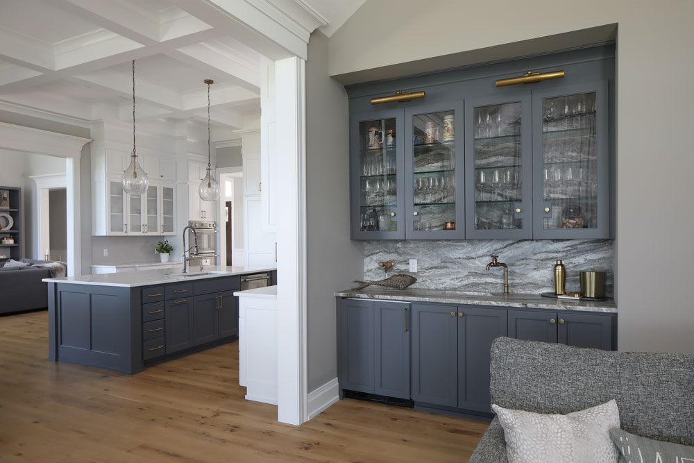 home bar with blue cupboards and marble counter tops