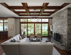 lower living area with seating, a chandelier, and stone fireplace