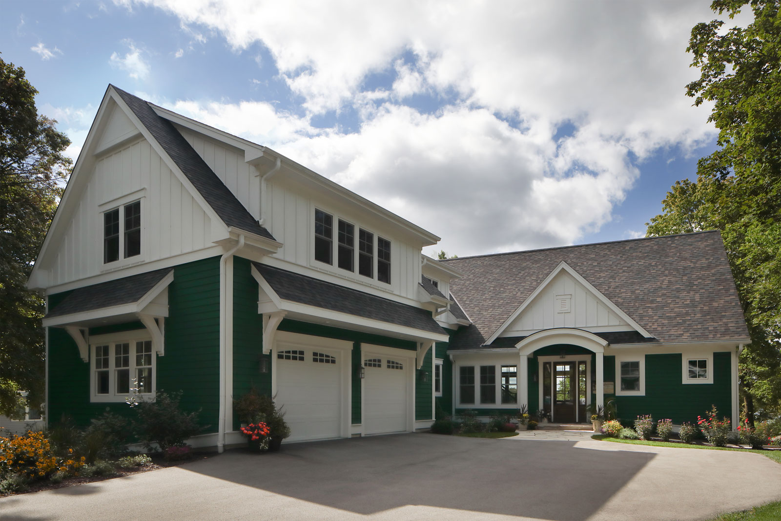 image of a white and dark green home exterior with a two car garage